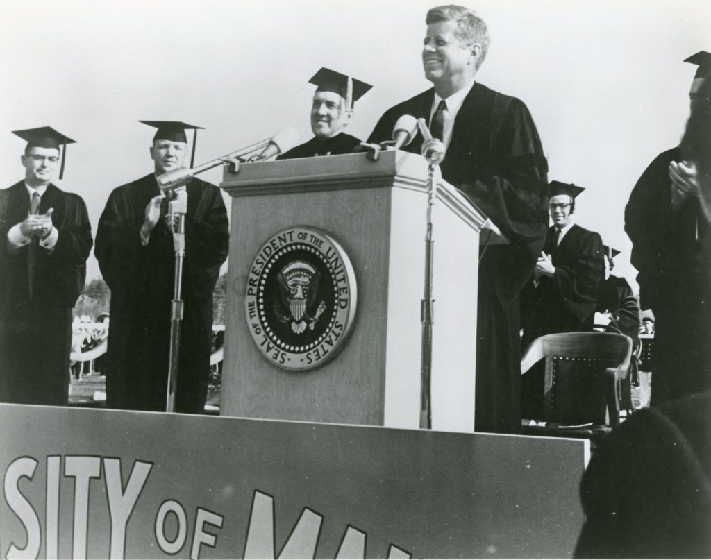 A black and white photo of President John F. Kennedy giving a speech at the University of Maine in 1963, shortly before his assassination.