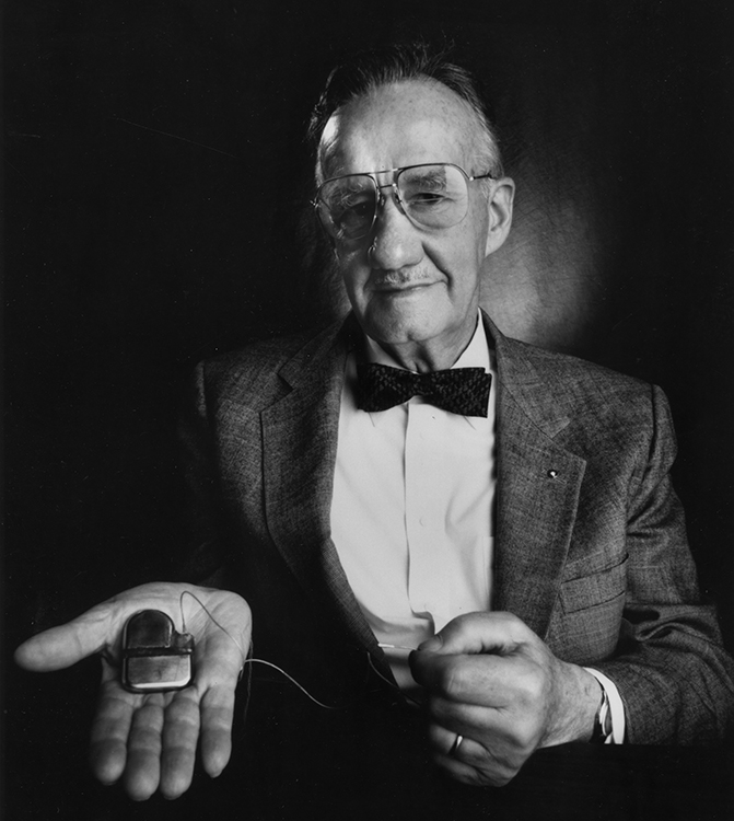 A black and white photo of Wilson Greatbatch holding an implantable cardiac pacemaker.