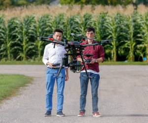 Students use a drone in a corn field