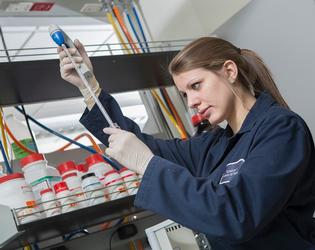 Student testing chemicals in a lab