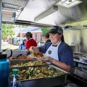 A young lady scooping food onto a plate during a service project.